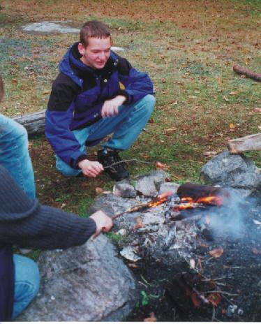 Keith maintains the campfire.