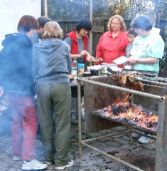 Members of the Czech Scouting families prepare half-pig on a spit